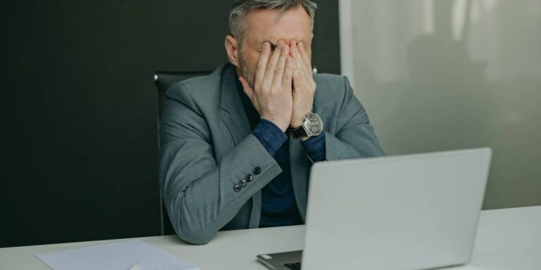 Man frustrated at laptop - representing why is my internet so slow
