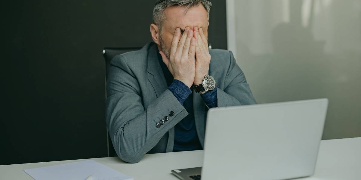 Man frustrated at laptop - representing why is my internet so slow